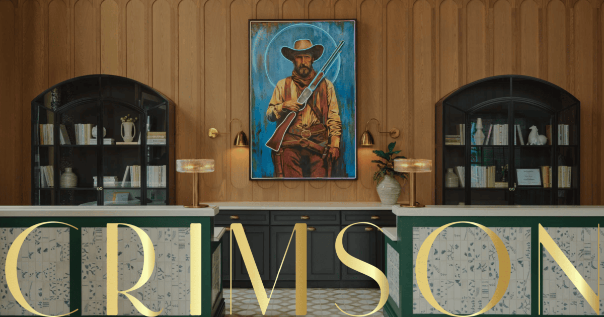 A western-style painting of a man with a rifle hangs on a wood-paneled wall above a reception desk with the word "CRIMSON" in gold letters. Shelves with books and decor flank the desk. | Wonderly