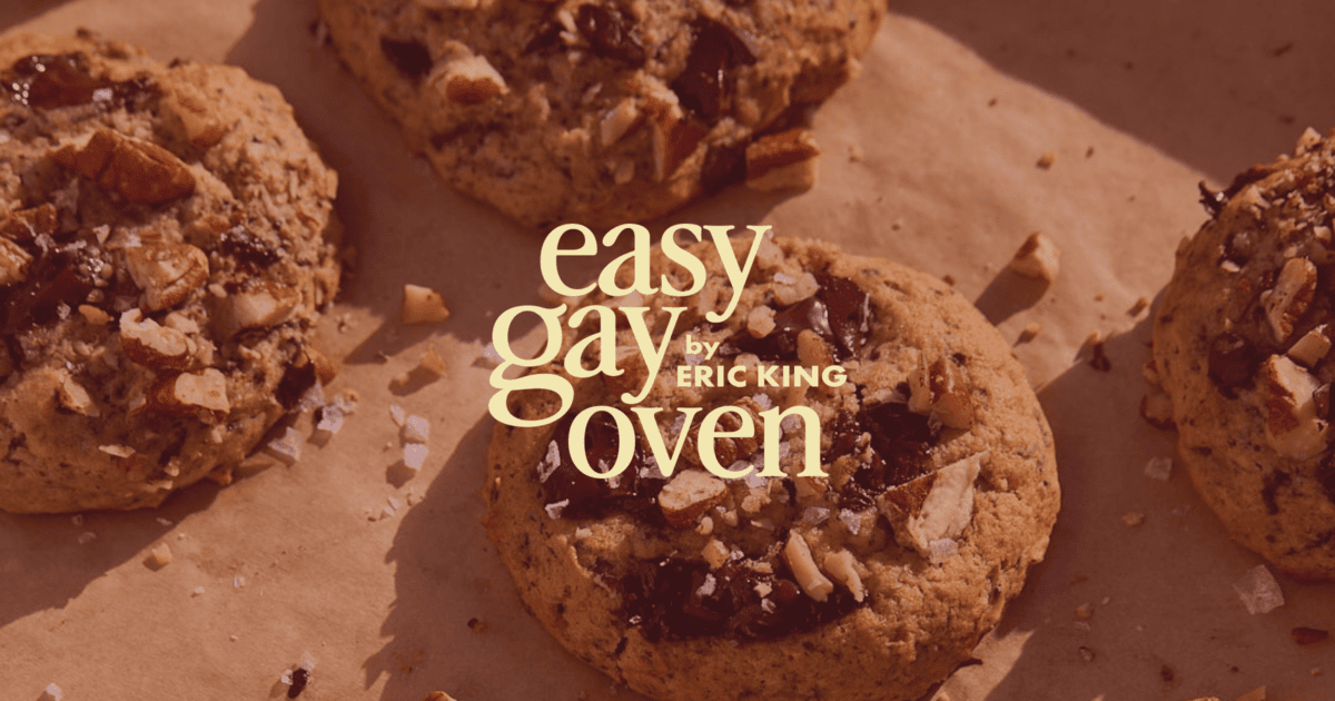 Chocolate chip cookies with chopped nuts and sea salt on parchment paper, with the text "easy gay oven by Eric King" overlaid in the center. | Wonderly