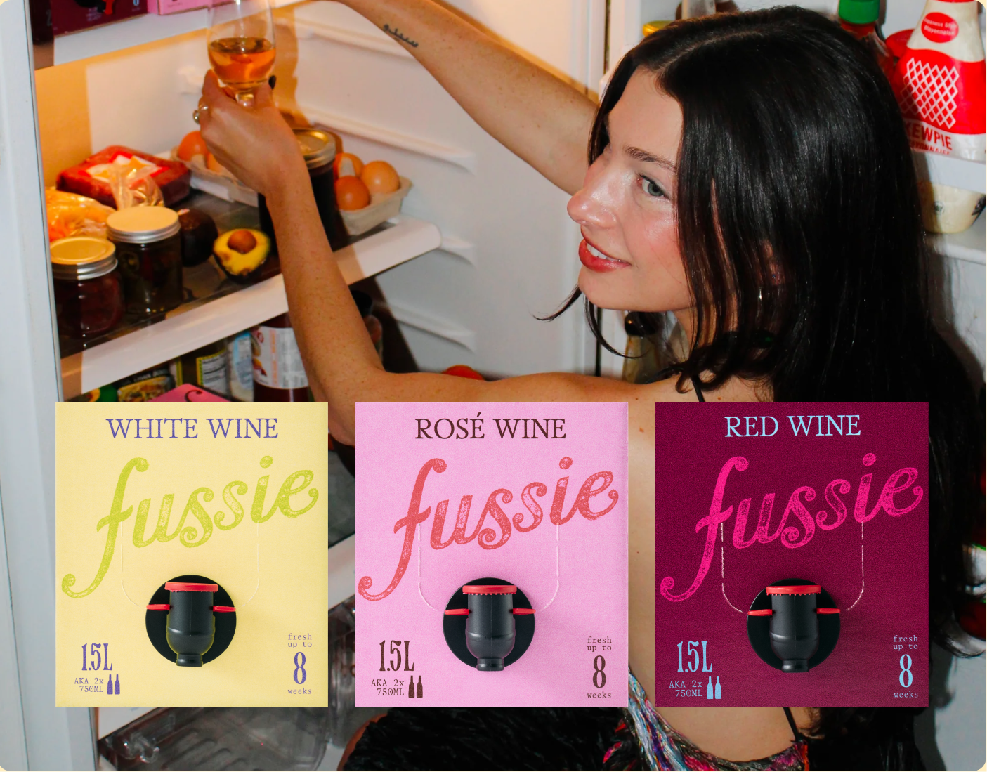 Woman pouring boxed wine from fridge and 3 Fussie boxes layered on top