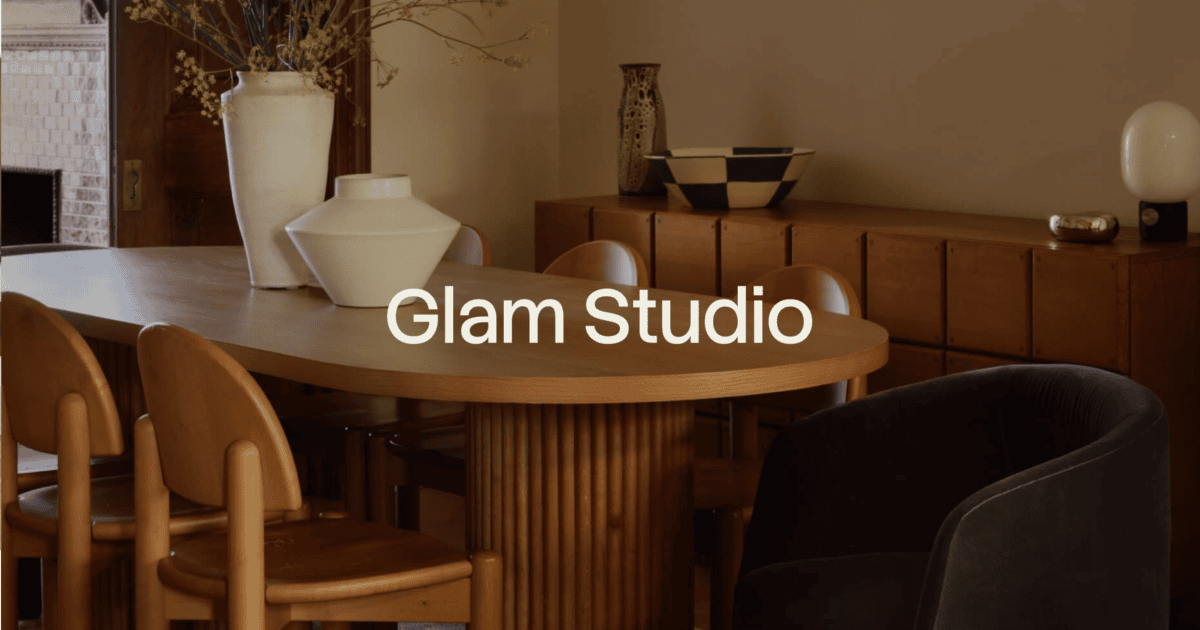 A modern dining room with a wooden table, tan chairs, decorative vases, and a sideboard, with the text "Glam Studio" centered over the image. | Wonderly