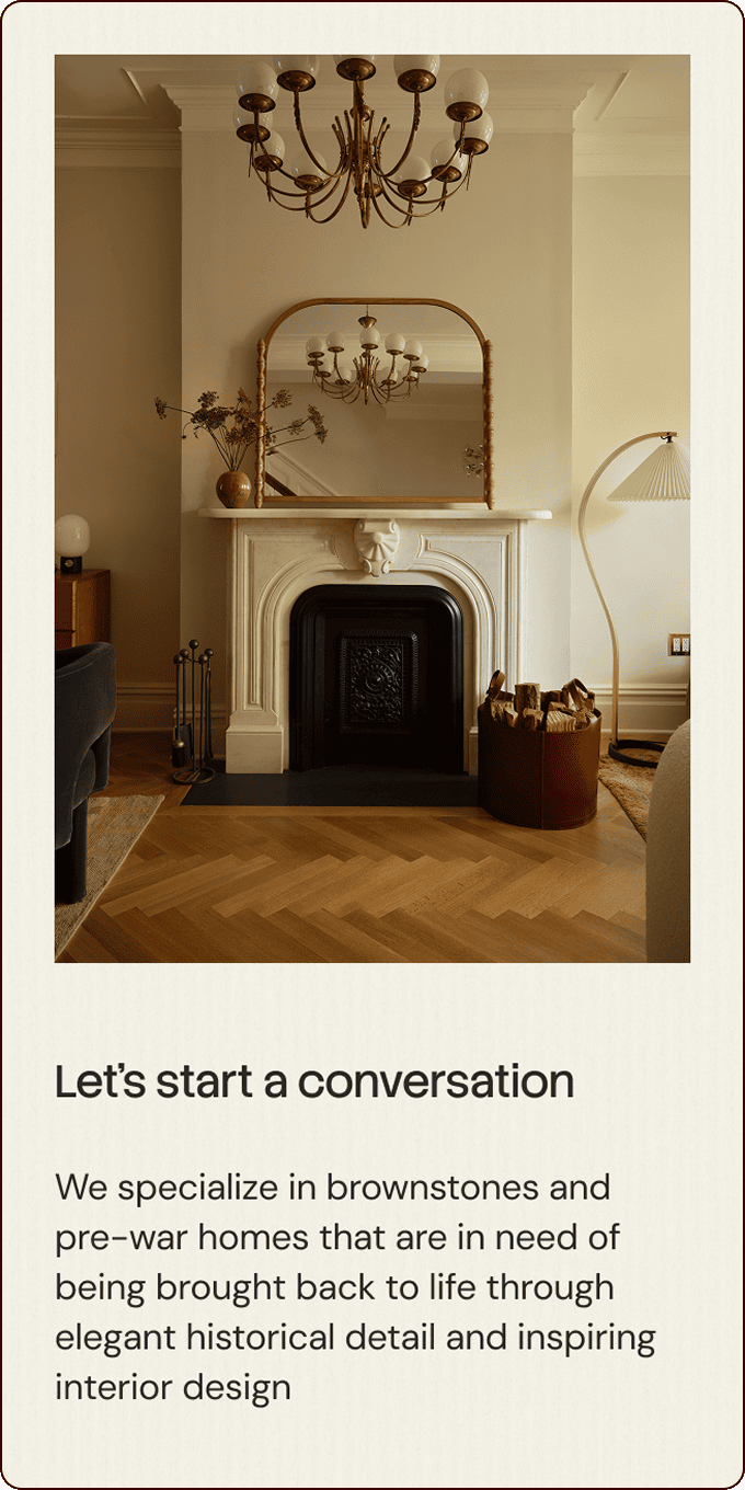 A stylish living room features a white fireplace with a mirror above, chandelier, armchair, and modern lamp; the text promotes historical interior design for brownstone and pre-war homes. | Wonderly