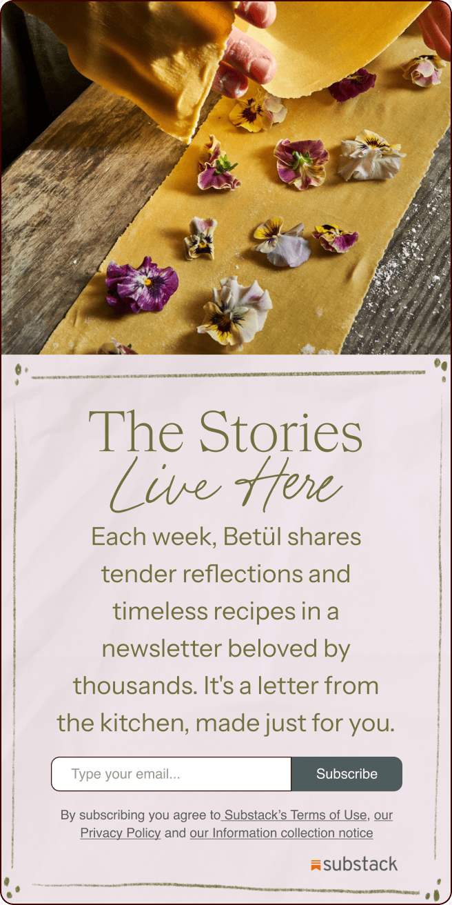 A hand arranges edible flowers on a sheet of dough; below is a Substack newsletter signup promoting recipes and reflections by Betül. | Wonderly