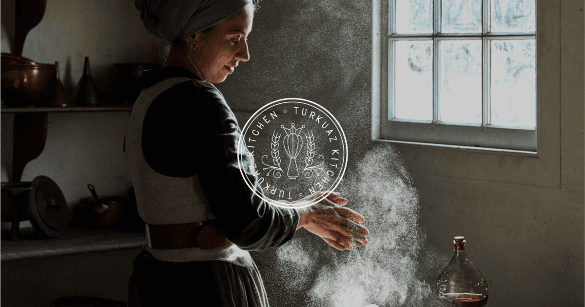 A woman in a headscarf claps flour from her hands in a rustic kitchen with light streaming through a window; kitchen utensils and a glass bottle are visible. | Wonderly
