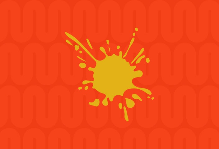 A yellow paint splatter on an orange background with a repeating geometric pattern. | Wonderly