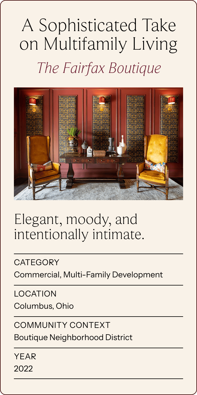 Two yellow leather chairs and a bench sit in a stylish lobby with red paneled walls, floral screens, and plants, promoting a boutique multifamily development in Columbus, Ohio. | Wonderly